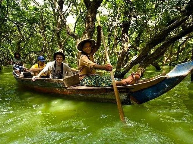 Touristen genießen eine Bootsfahrt durch den überfluteten Mangrovenwald von Kampong Phluk.
