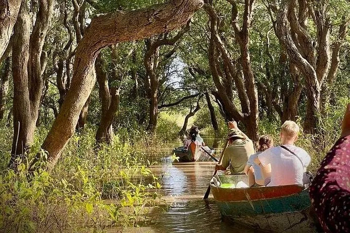 Touristen genießen eine Bootsfahrt durch einen überfluteten Wald